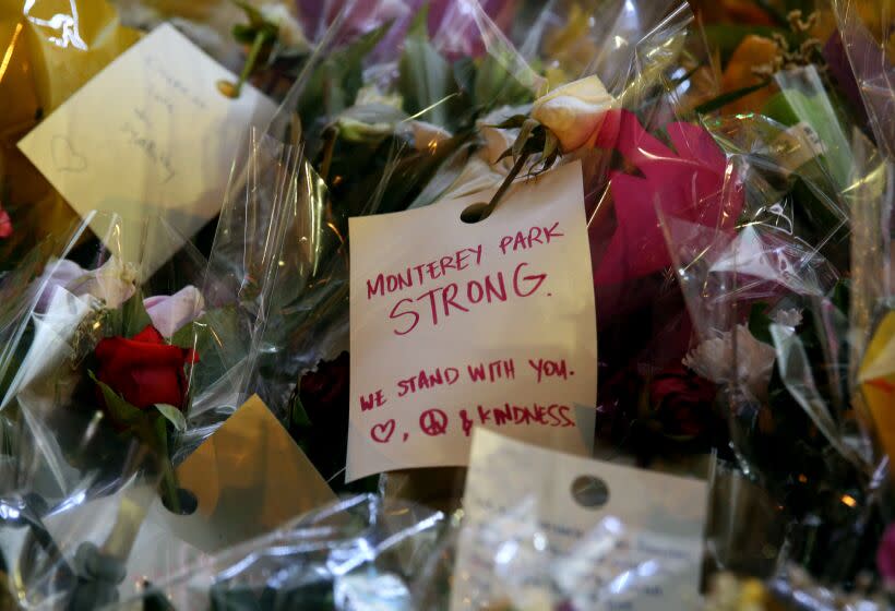 A note attached to flowers left for the 11 shooting victims, at the memorial site in front of Star Ballroom Dance Studio in Monterey Park on Thursday, Jan. 26, 2023.