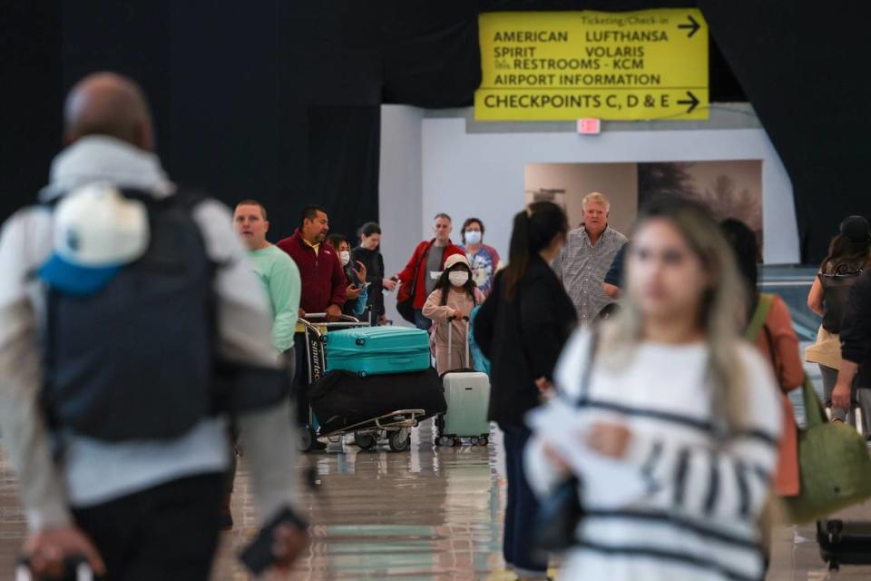 People walk through the terminal at Charlotte Douglas International Airport on Friday, September 30, 2022. Despite several flights being cancelled due to inclement weather from Hurricane Ian, it was business as usual at the airport.