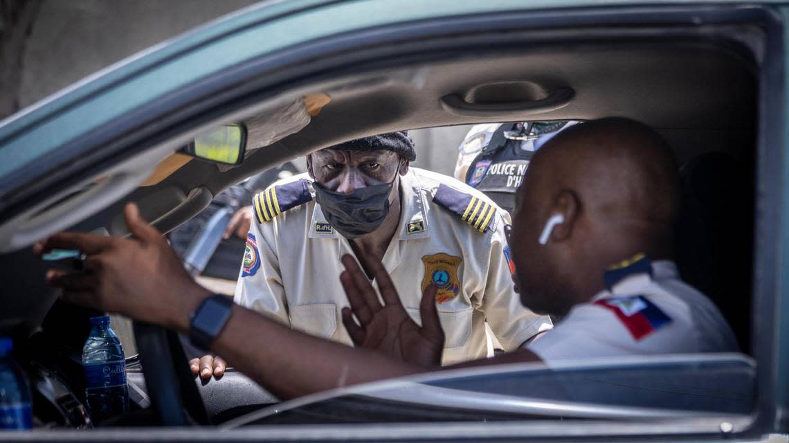 A policeman patrolling with no body armor and just his regular uniform listens to Tabarre Police Commissioner Livenston Gauthier during a field visit on June 23, 2022. Parts of the district are increasingly becoming a red zone due to gang violence.