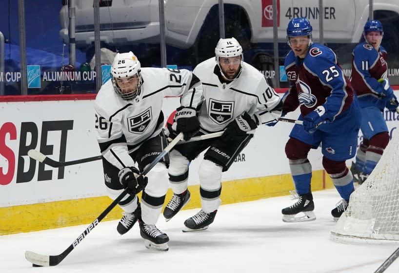 Los Angeles Kings defenseman Sean Walker, left, collects the puck as center Michael Amadio.
