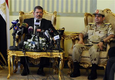 Egypt's President Mohamed Mursi (L) and Defence Minister Abdel Fattah al-Sisi (R) attend a news conference on the release of the soldiers who were kidnapped last week, in Cairo in this May 22, 2013 file photo. REUTERS/Stringer