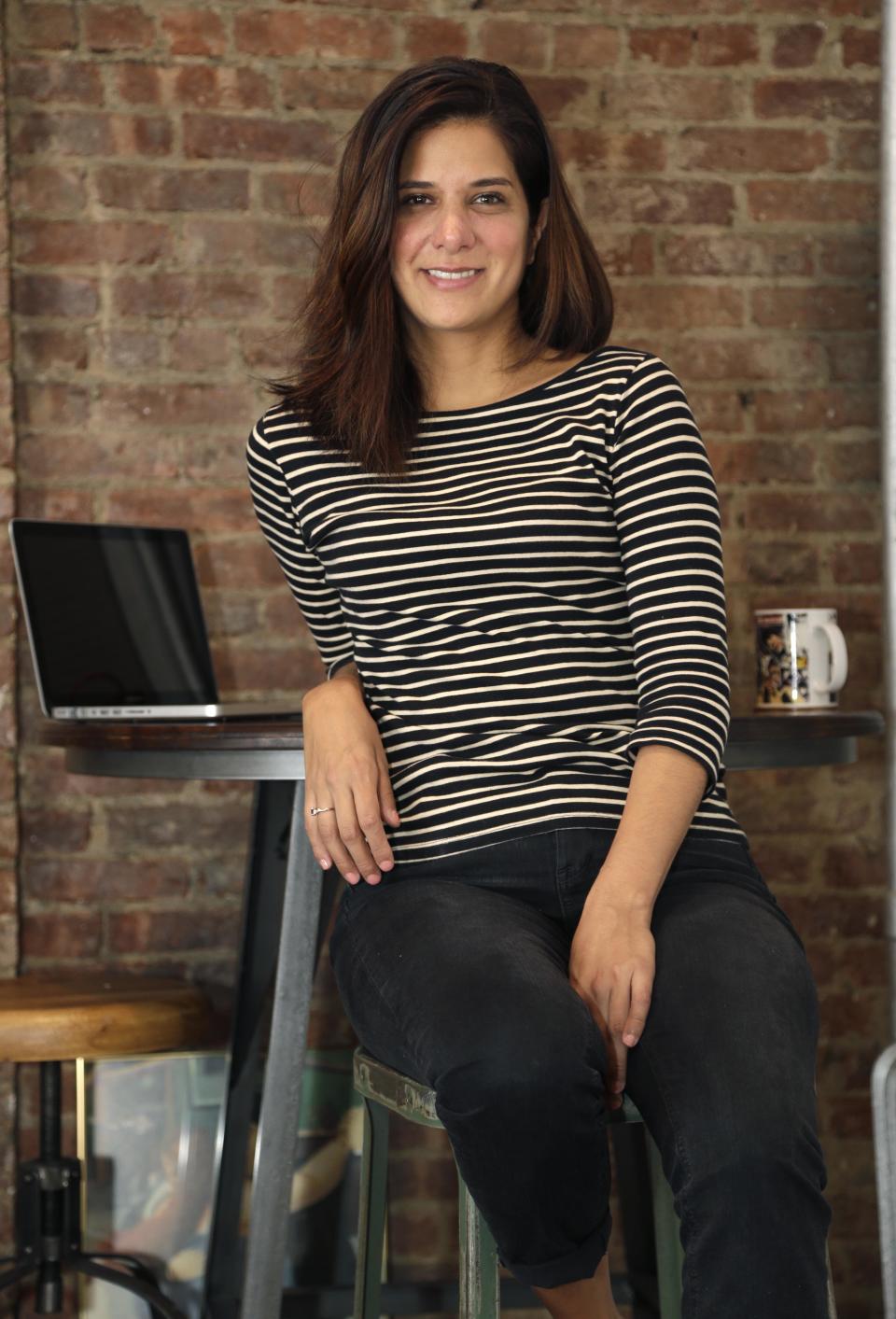 Mishelle Farer poses for picture in her apartment, where she rents a room on Airbnb, in New York, Thursday, Oct. 10, 2013. Farer is an avid user of Airbnb, a website that allows travelers to rent other people's homes or rooms. (AP Photo/Seth Wenig)