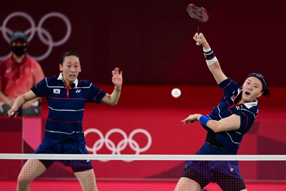 <p>South Korea's Shin Seung-chan (R) hits a shot next to South Korea's Lee So-hee in their women's doubles badminton semi-final match against Indonesia's Greysia Polii and Indonesia's Apriyani Rahayu during the Tokyo 2020 Olympic Games at the Musashino Forest Sports Plaza in Tokyo on July 31, 2021. (Photo by Pedro PARDO / AFP)</p> 