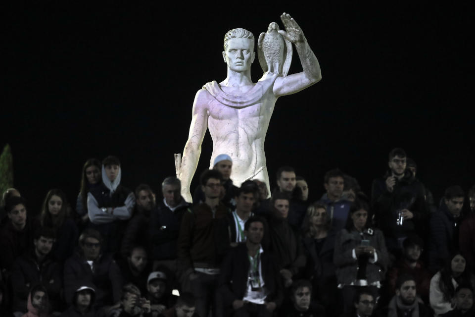 FILE - One of the statues by sculptor Eugenio Baroni adorns the Pietrangeli tennis stadium behind spectators watching a match at the Italian Open tennis tournament, in Rome, Thursday, May 16, 2019. The tennis stadium is part of the Foro Italico sports complex, which was initially called Foro Mussolini (Mussolini's Forum). Italy's failure to come to terms with its fascist past is more evident as it marks the 100th anniversary, Friday, Oct. 28, 2022, of the March on Rome that brought totalitarian dictator Benito Mussolini to power as the first postwar government led by a neo-fascist party takes office. (AP Photo/Andrew Medichini, File)