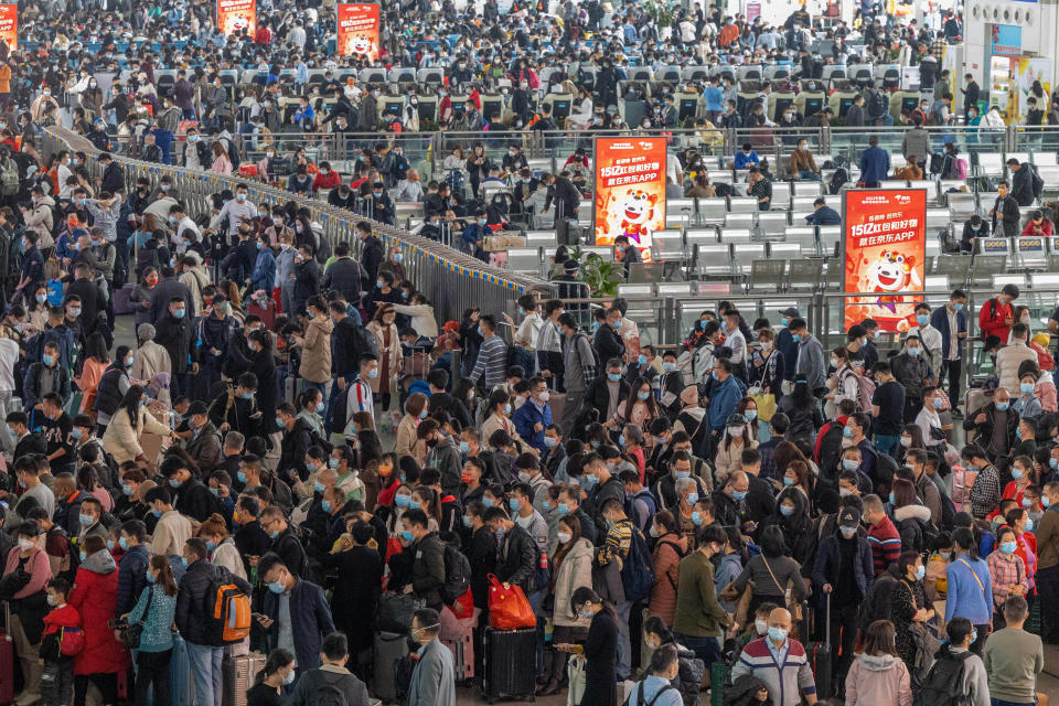 Travelers wearing face masks to protect against COVID-19 line up for trains at a station in Guangzhou in southern China's Guangdong Province, Friday, Jan. 28, 2022. Chinese are traveling to their hometowns for the Lunar New Year, the country's biggest family holiday, despite a government plea to stay where they are as Beijing tries to contain coronavirus outbreaks. (Chinatopix via AP)