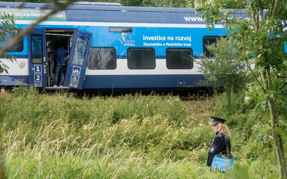 A policewoman stands in front of one of two collided trains - MICHAL CIZEK 