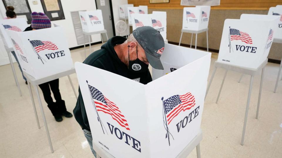 PHOTO: Chris Helps, of Earlham, Iowa, fills out his ballot during early voting, Tuesday, Oct. 20, 2020, in Adel, Iowa. (Charlie Neibergall/AP)