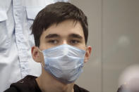 Ilnaz Galyaviyev, wearing a face mask to protect against coronavirus, sits in a courtroom in Kazan, Russia, Wednesday, May 12, 2021. Russian officials say Galyaviyev attacked a school in the city of Kazan and Russian officials say several people have been killed. Russian media said the gunman was a former student at the school who called himself "a god" on his account on the messaging app Telegram and promised to "kill a large amount of biomass" on the morning of the shooting. Authorities also say over 20 others have been hospitalised with wounds. (AP Photo/Dmitri Lovetsky)