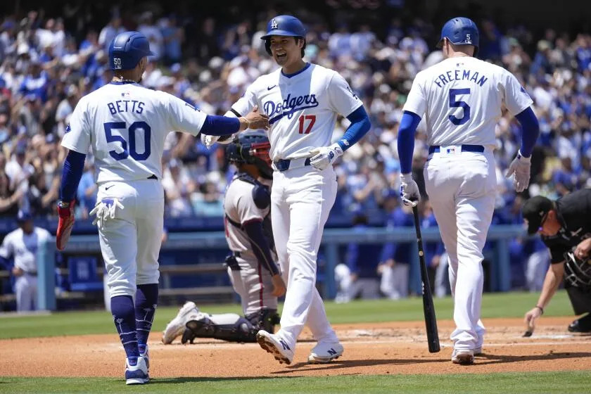 Los Angeles Dodgers designated hitter Shohei Ohtani (17) celebrates with Mookie Betts (50) and Freddie Freeman (5) after hitting a home run during the first inning of a baseball game against the Atlanta Braves in Los Angeles, Sunday, May 5, 2024. Betts also scored. (AP Photo/Ashley Landis)