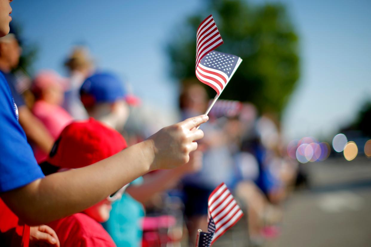 A child waves an American flag July 3, 2021, during the LibertyFest Parade in celebration of the Fourth of July in Edmond.