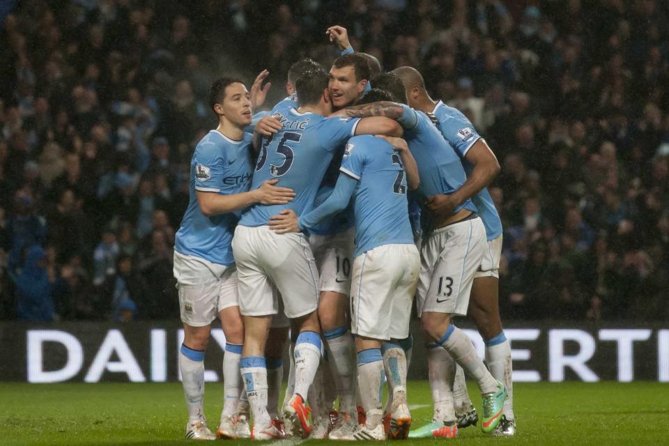 Manchester City's Edin Dzeko, centre, celebrates with teammates after scoring his second goal against Aston Villa during their English Premier League soccer match at the Etihad Stadium, Manchester, England, Wednesday May 7, 2014. (AP Photo/Jon Super)