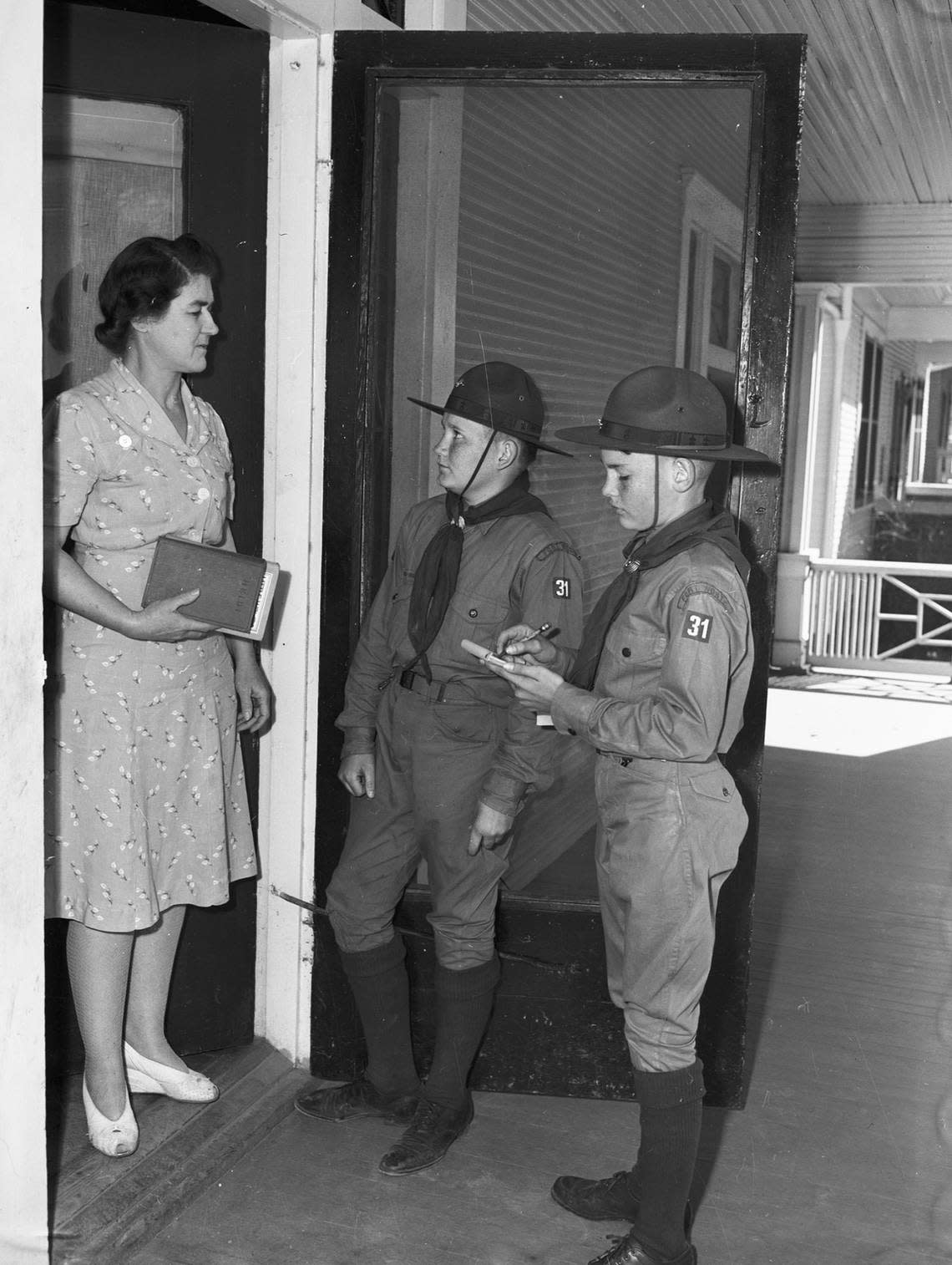 Feb. 11, 1943: As a part of National Boy Scout Week, scouts will go door-to-door asking residents to bring books for the Victory Book Campaign to schools when they register for Ration Book 2, Feb. 24-27. Standing at the door is Mrs. R.C. Reynolds. The scouts collecting books are Patrick Finn and Billy Singleton, of Troop 31 at Saint Mary’s Catholic Church. Fort Worth Star-Telegram archive/UT Arlington Special Collections