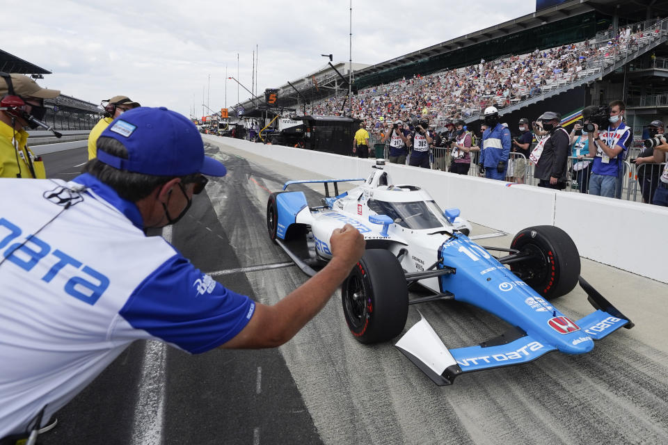 A crew member greets Alex Palou, of Spain, as he pulls in during qualifications for the Indianapolis 500 auto race at Indianapolis Motor Speedway, Sunday, May 23, 2021, in Indianapolis. (AP Photo/Darron Cummings)