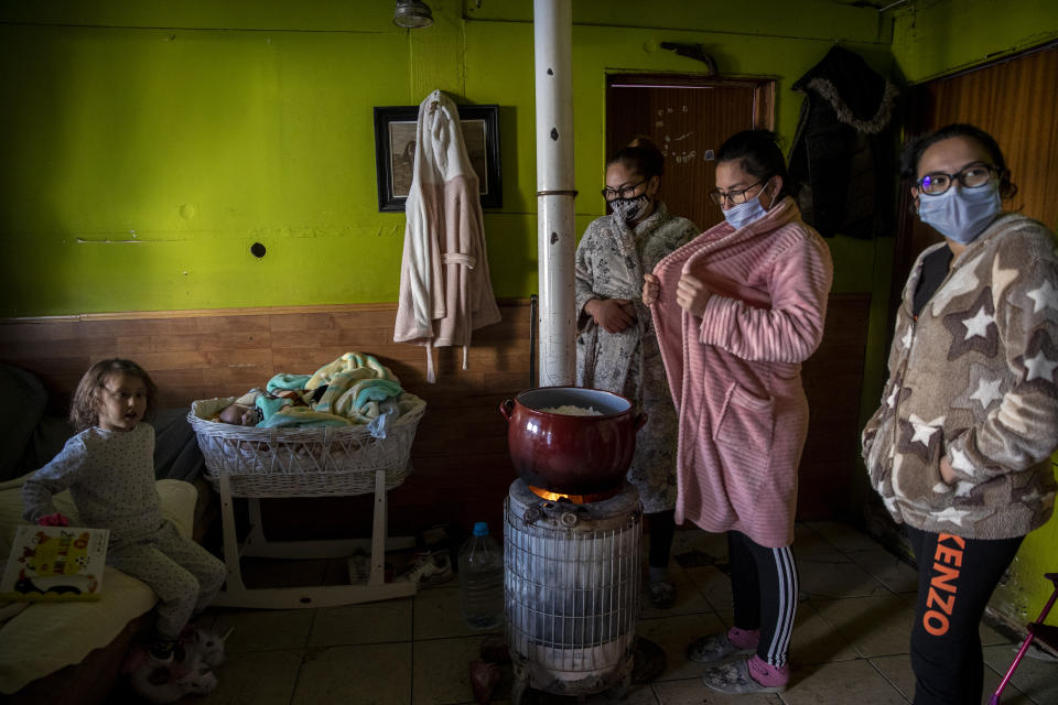 La familia Fernández y el bebé Jesús, de un mes de nacido, en su casa en La Cañada Real Galiana, un enorme barrio pobre a las afueras de Madrid, España, considerado uno de los más grandes de Europa, el 12 de enero de 2021. (AP Foto/Manu Fernandez)