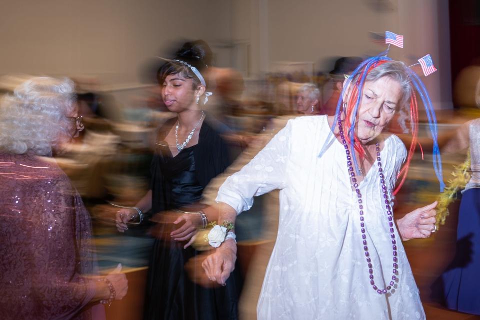 Hanna Weidgams, Royal Palm Beach, dances while wearing a headband decorated with U.S. flags during a 'Young At Heart' prom for seniors held at the the Royal Palm Beach Cultural Center on Friday, May 26, 2023, in Royal Palm Beach, Fla. "I can't walk," she said, "but I can dance."