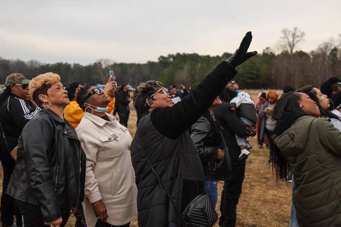 Salamondra Robinson, center, points her hand toward the sky and remarks how all the balloons are moving together in the same direction as family and friends gather on what would have been Shanquella Robinson’s 26th birthday at Beatties Ford Memorial Garden, where she is buried, on Sunday, January 8, 2023.