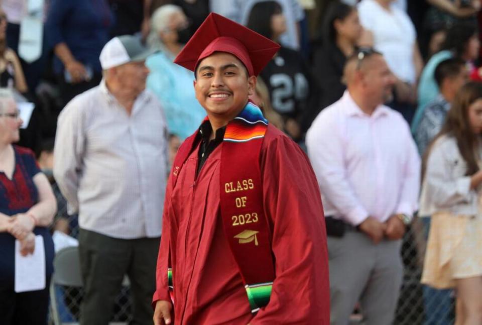 A graduate walks in at the start of the first graduation ceremony for Matilda Torres High School at Madera Memorial Stadium on June 10, 2023.