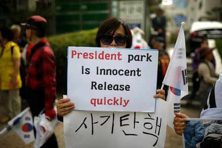 A supporter of South Korean ousted leader Park Geun-hye holds a sign in front of a court in Seoul, South Korea, May 23, 2017. REUTERS/Kim Hong-Ji