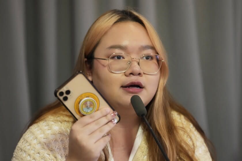 Pro-democracy activist Panusaya Sithijirawattanakul shows her mobile phone during a news conference in Bangkok, Thailand, Monday, July 18, 2022. Cybersecurity researchers say that Thai activists involved in the country's pro-democracy protests had their cellphones or other devices infected and attacked with government-sponsored spyware. (AP Photo/Sakchai Lalit)