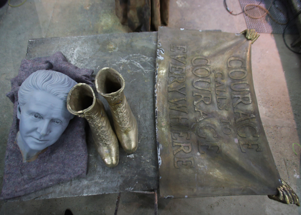 <em>A 3D-printed head – used as a starting point to model the finished head of the statue – alongside a banner and a pair of boots that will be fitted to the statue (PA)</em>