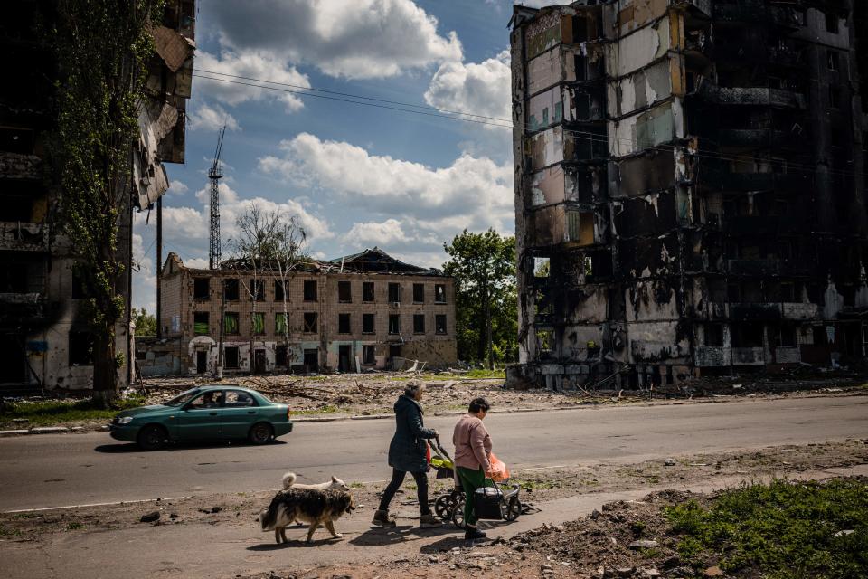 Local residents walk by a destroyed apartment building in the town of Borodyanka on June 1, 2022, amid the Russian invasion of Ukraine.