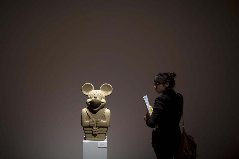 A woman looks at a sculpture by Nadin Ospina titled 'Idol with Skull' on exhibit at the Casa Daros museum in Rio de Janeiro, Brazil, Wednesday, March 20, 2013. Local officials aiming to transform Rio de Janeiro from a sleepy cultural backwater into an art hotspot are inaugurating this week Casa Daros, a new museum that draws on one of the world's premier collections of contemporary Latin American art. Casa Daros, a 12,000-square meter (129,000-square foot) exhibition space housed in a renovated 1866 mansion, will bring to Rio some of the around 1,200 pieces acquired over the past 13 years by independently wealthy Zurich-based collector Ruth Schmidheiny. (AP Photo/Felipe Dana)