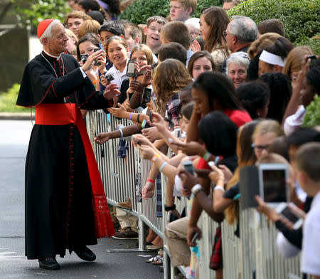 The Archbishop of Washington, Donald Wuerl (L), greets schoolchildren at the Vatican embassy in Washington September 24, 2015. REUTERS/Gary Cameron/Files