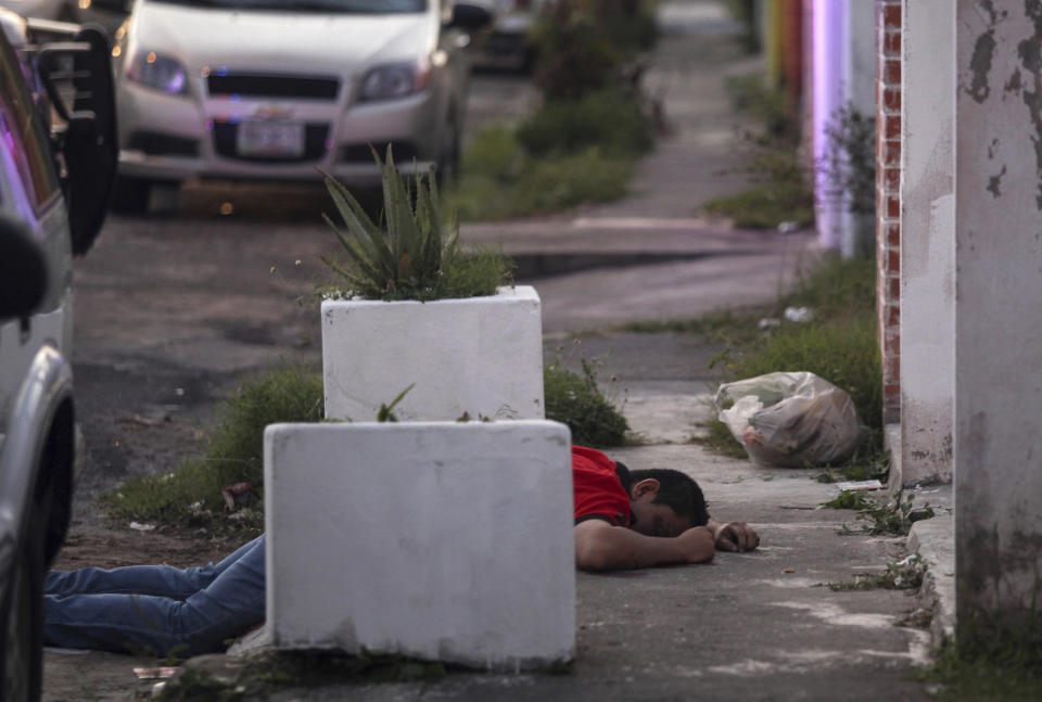 Un hombre yace muerto en la calle después de haber recibido disparos de atacantes desconocidos en una zona en la que se estaban realizando saqueos en la ciudad portuaria de Veracruz, México, el jueves 5 de enero de 2017. El fiscal del estado de Veracruz confirmó que dos personas murieron y que los atacantes no han sido identificados. (AP Foto/Félix Márquez)