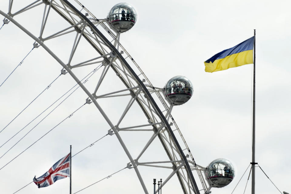 A Union Jack flag and a Ukraine flag fly over government buildings in front of the London Eye on Ukraine Independence Day in London, Wednesday Aug. 24, 2022. (AP Photo/Frank Augstein)