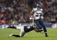 Seattle Seahawks running back Chris Carson (32) runs clear of Oakland Raiders defensive back Dominique Rodgers-Cromartie (45) during the second half of an NFL football game at Wembley stadium in London, Sunday, Oct. 14, 2018. (AP Photo/Tim Ireland)