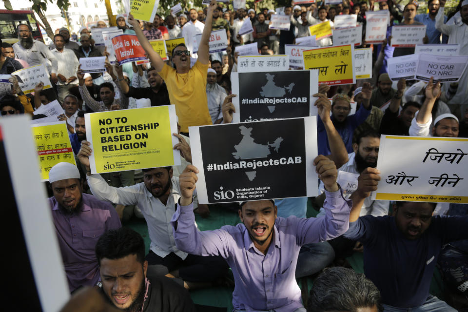 Indians holds placards and shouts slogans during a protest against Citizenship Amendment Act in Ahmadabad, India, Sunday, Dec. 15, 2019. Protests have been continuing over a new law that grants Indian citizenship based on religion and excludes Muslims. (AP Photo/Ajit Solanki)