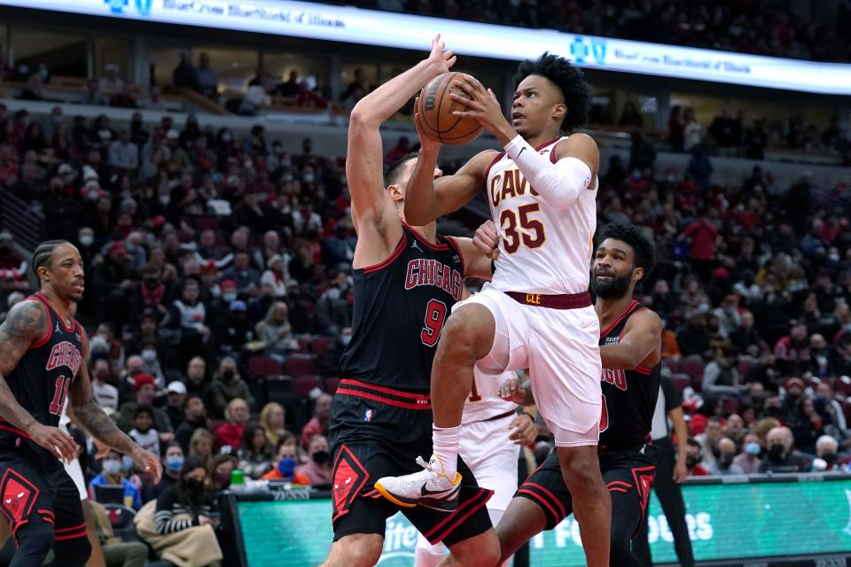 Cleveland Cavaliers' Isaac Okoro (35) drives past Chicago Bulls' Nikola Vucevic during the first half of an NBA basketball game Wednesday, Jan. 19, 2022, in Chicago. (AP Photo/Charles Rex Arbogast)