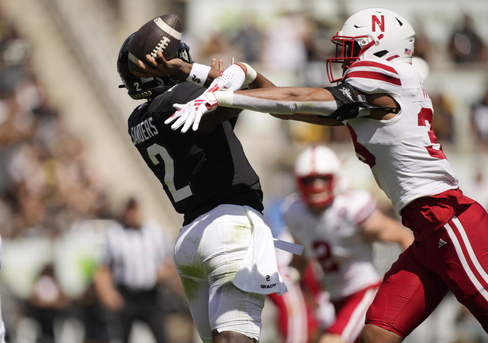 Nebraska linebacker Javin Wright, right, hits the throwing arm of Colorado quarterback Shedeur Sanders as he unloads a pass in the second half of an NCAA college football game Saturday, Sept. 9, 2023, in Boulder, Colo. (AP Photo/David Zalubowski)