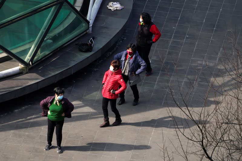 Women wearing masks exercise at a community in Shanghai