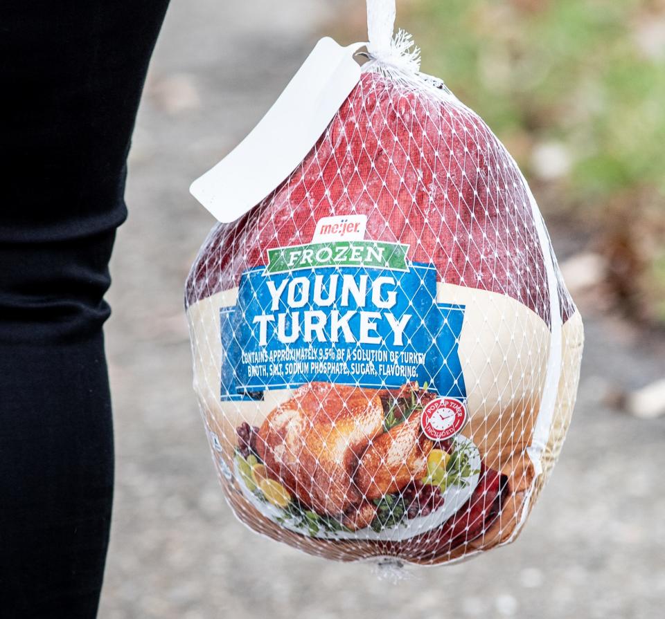 A woman carries a turkey ahead of Thanksgiving. Millions of turkeys have died this year as a result of a bird flu outbreak that has spread across the country, which is significantly raising prices of the birds ahead of the holiday dinner.