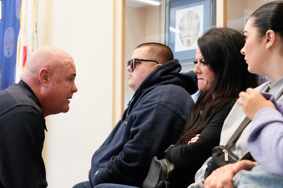 Capt. Jamie Bennett of the Los Angeles Police Department speaks to Sandy DeLaMora, the widow of Jose Quezada, after a news conference where detectives announced the arrest of two suspects in connection with Quezada's murder. Quezada, a longtime community supporter and youth sports coach, was shot and killed in a city park July 27, 2023. He became the subject of a USA TODAY special report in late 2023, when his killing remained unsolved.