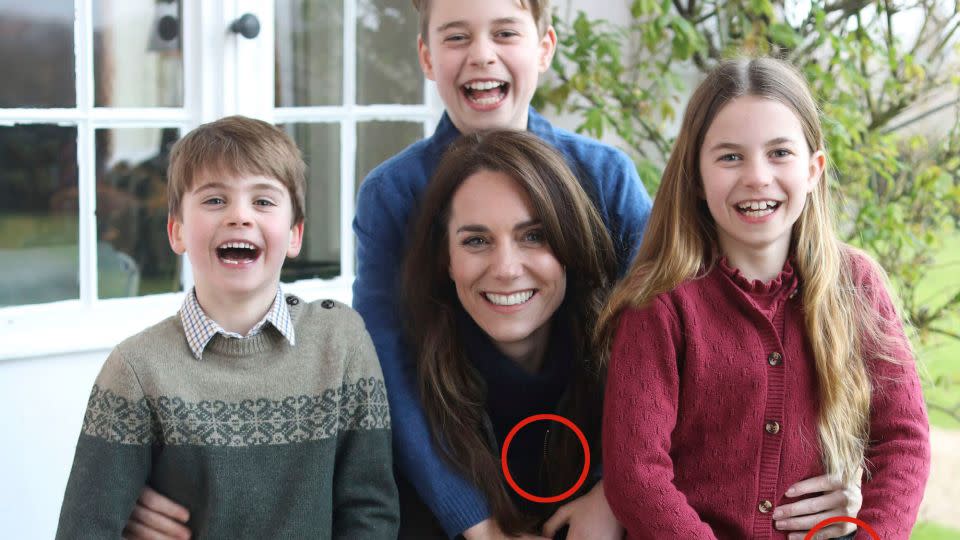 This photo released by Kensington Palace shows Kate, Princess of Wales, with her children, Prince Louis, left, Prince George and Princess Charlotte. The circled areas appear to show evidence of potential manipulation, including Princess Charlotte’s sleeve cuff and a zipper on the lefthand side of the jacket of the Princess of Wales, which does not appear to be aligned. - Kensington Palace