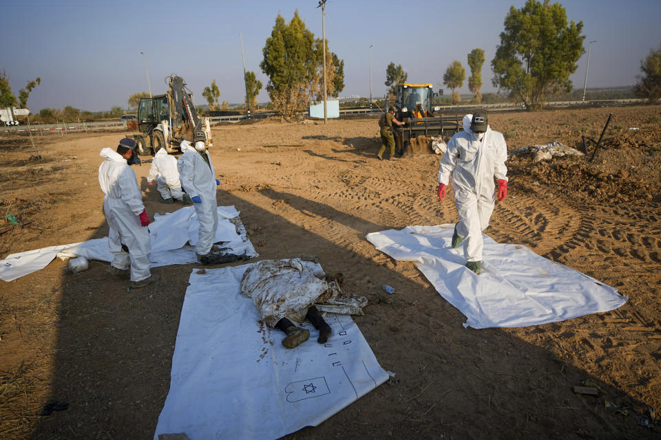 Israeli soldiers remove the bodies of Hamas militants from Kibbutz Be'eri, Israel, Saturday, Oct. 14, 2023. The kibbutz was overrun by Hamas militants from the nearby Gaza Strip on Cot.7, when they killed and captured many Israelis. (AP Photo/Ariel Schalit)