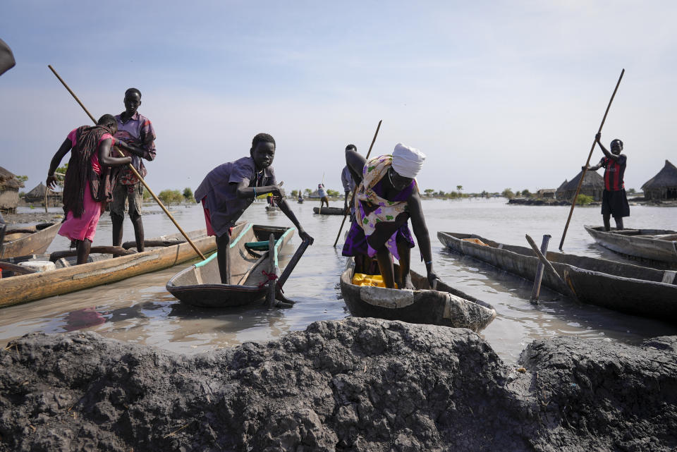 FILE - Residents park their dugout canoes next to a mud dyke they built to try and prevent flooding, in New Fangak town in Jonglei state, South Sudan on Dec. 25, 2021. A petition to stop the revival of the 118-year-old Jonglei Canal project in South Sudan, started by one of the country's top academics, is gaining traction in the country, with the waterway touted as a catastrophic environmental and social disaster for the country's Sudd wetlands. (AP Photo/Sam Mednick, File)