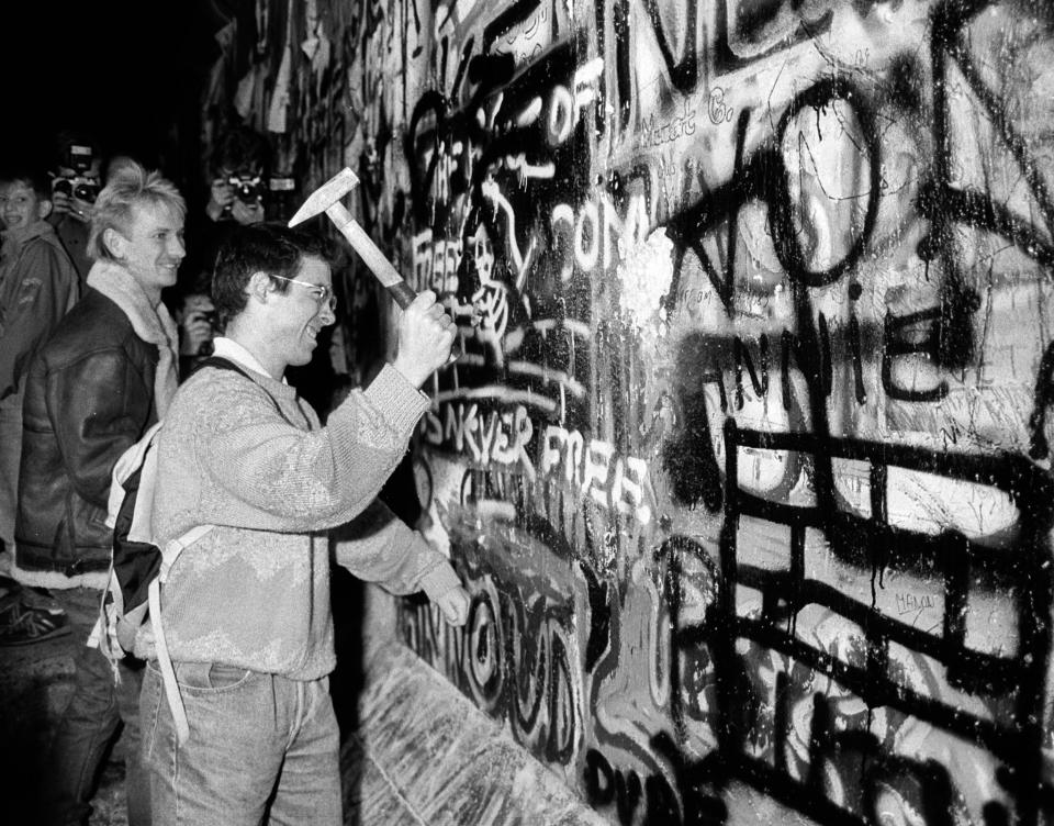 A man hammers a section of the Berlin Wall near the Brandenburg Gate after the opening of the East German border was announced in this  Nov. 9, 1989. (Photo: Fabrizio Bensch/Reuters)