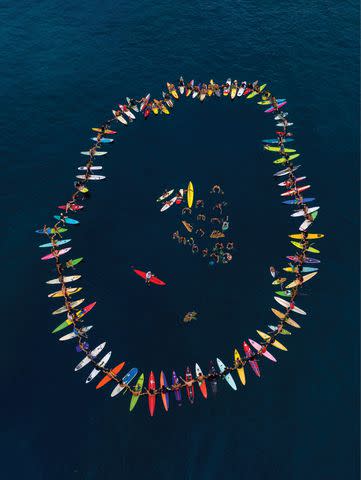 <p>Tom Servais</p> Photo of a surf paddle out, featured in book "Carissa Moore: Hawaii Gold: A Celebration of Surfing"