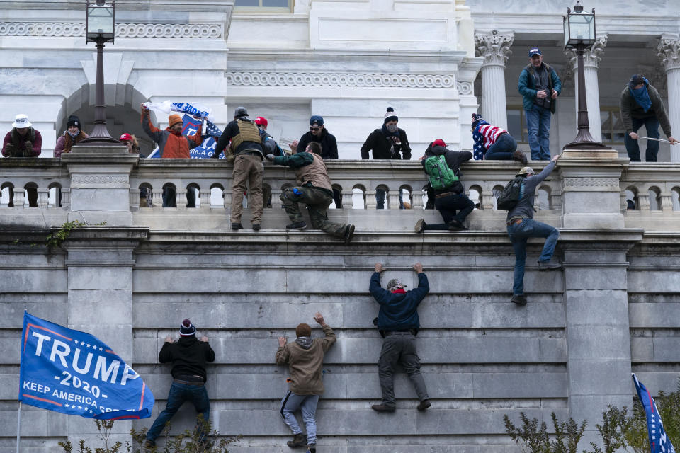 Supporters of President Donald Trump climb the West wall of the the U.S. Capitol on Wednesday, Jan. 6, 2021, in Washington. (AP Photo/Jose Luis Magana)