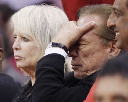 Los Angeles Clippers owner Donald Sterling (R) puts his hand over his face as he sits courtside with his wife Shelly (L) while the Clippers trail the Chicago Bulls in the second half of their NBA basketball game in Los Angeles in this December 30, 2011 file photo. REUTERS/Danny Moloshok/Files