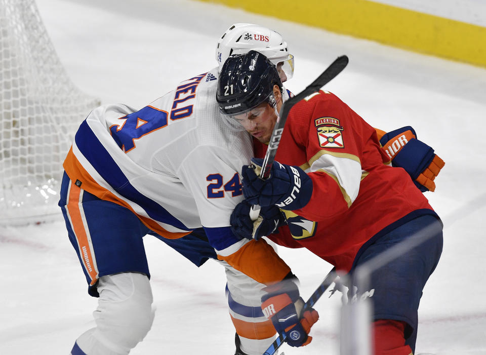 Florida Panthers center Nick Cousins (21) battles New York Islanders defenseman Scott Mayfield (24) during the second period of an NHL hockey game, Saturday, Dec. 2, 2023, in Sunrise, Fla. (AP Photo/Michael Laughlin)