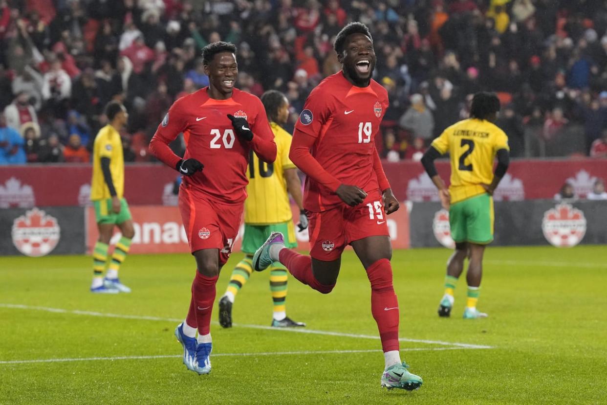 Canada's Alphonso Davies, No. 19, and Jonathan David, No. 20, are seen celebrating Davies's goal during the CONCACAF Nations League quarterfinal last November. They are among 26 players selected to the Canadian men's soccer team that will play in this year's Copa America. (Chris Young/The Canadian Press - image credit)