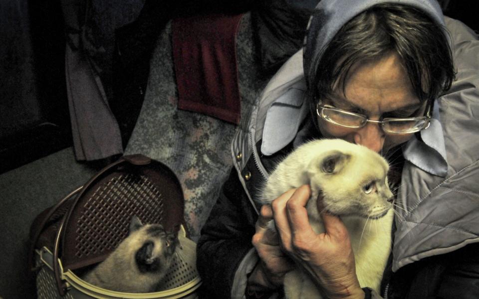 A woman escapes from Mariupol on Tuesday with her cats - EPA