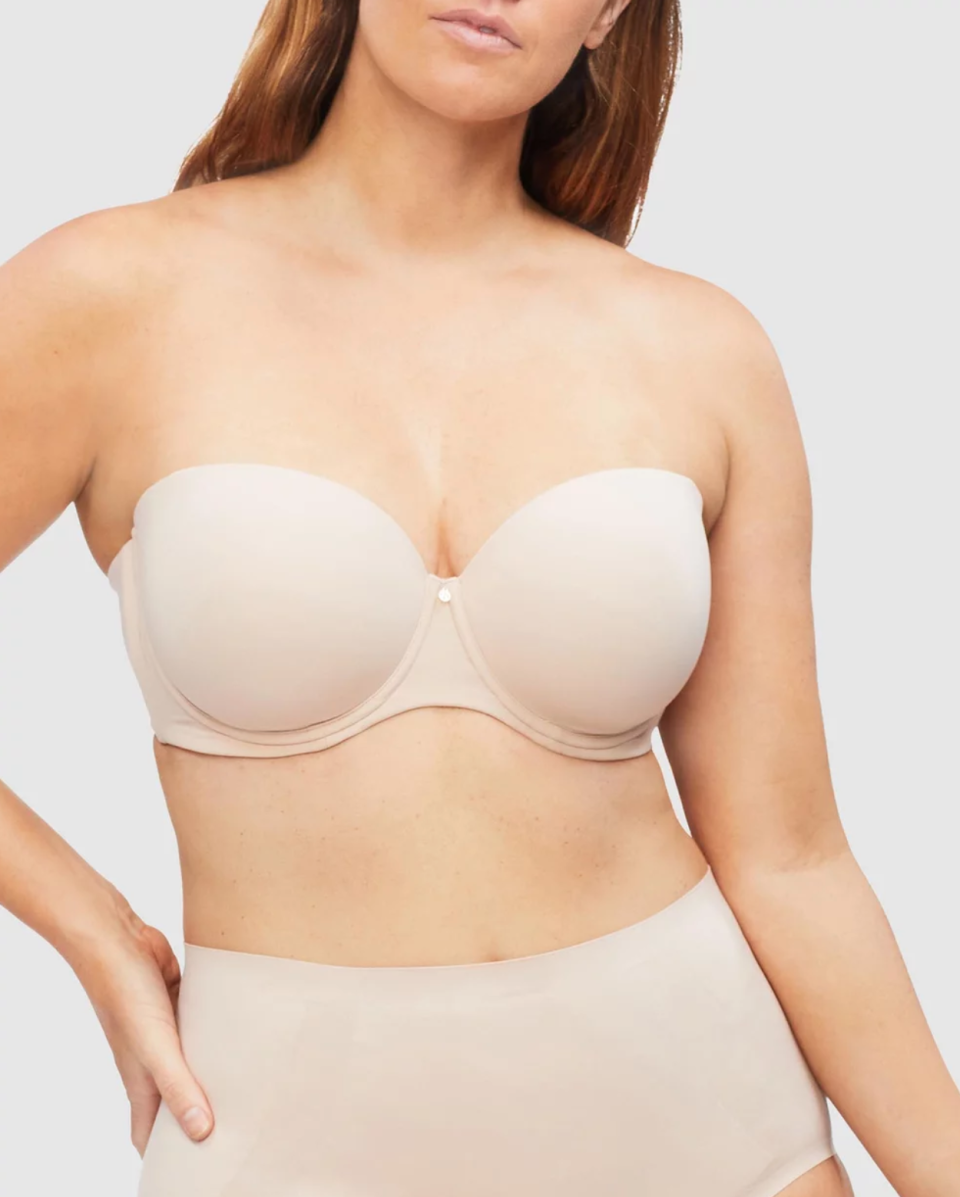 A model wears a beige Nancy Ganz Body Define Strapless Contour Bra and much full briefs.