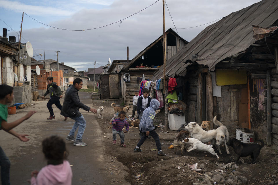 In this Nov. 12, 2018, photo, people run during a dog fight in a village near Kezmarok, Slovakia. An investigation by The Associated Press has found that women and their newborns in Slovakia are routinely, unjustifiably and illegally detained in hospitals across the European Union country. (AP Photo/Felipe Dana)