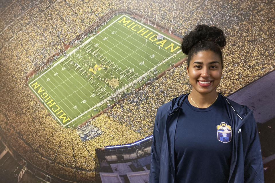 Michigan's Mimi Bolden-Morris, the first female graduate assistant football coach at Power Five school since the late 1980s, poses for a photo in front of a mural of Michigan Stadium, on Dec, 15, 2022, in Ann Arbor, Mich. (AP Photo/Larry Lage)