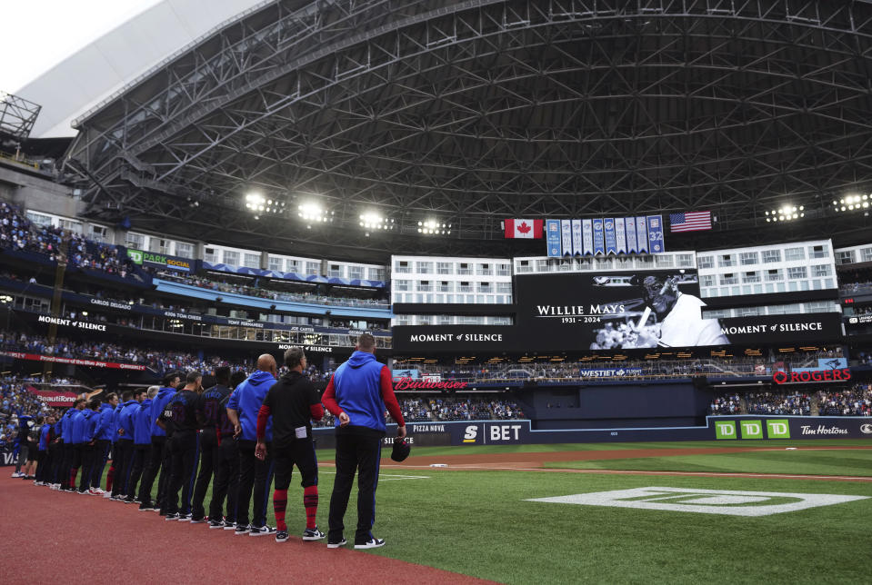 Toronto Blue Jays players and staff observe a moment of silence for Willie Mays before the team's baseball game against the Boston Red Sox on Wednesday, June 19, 2024, in Toronto. (Nathan Denette/The Canadian Press via AP)